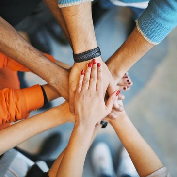 Images of multiple hands on top of each other portraying a culture of employees working together 