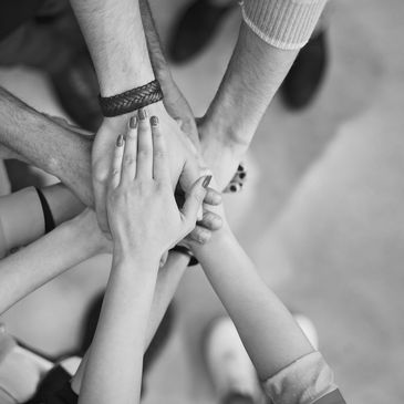 Multiple hands stacked together symbolizing unity and teamwork.