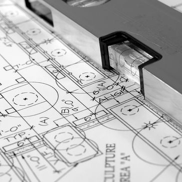 A spirit level placed on architectural blueprints.