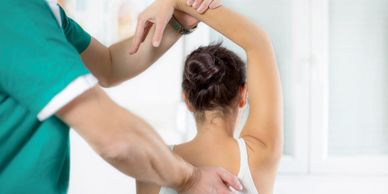 Home physiotherapy in South Delhi, assisting shoulder rehab with resistance therapy for pain relief.