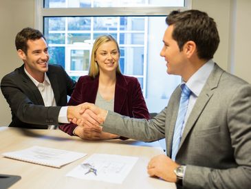 Business partners shaking hands outdoors.