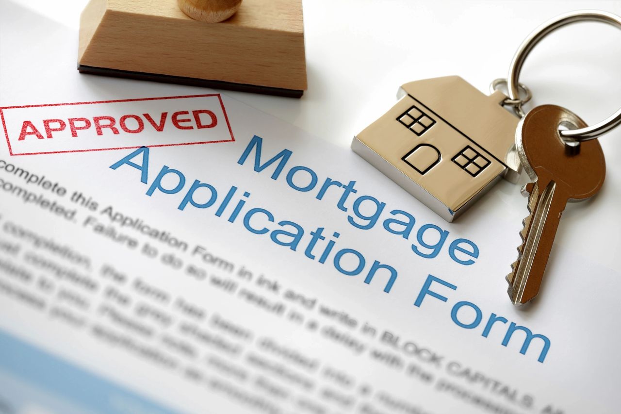 An approved mortgage application with keys to the new home.