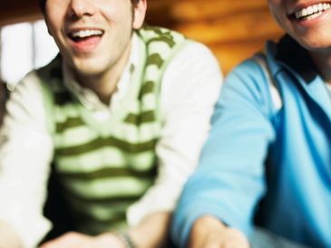 Two friends playing video games with controllers, focused and enjoying.