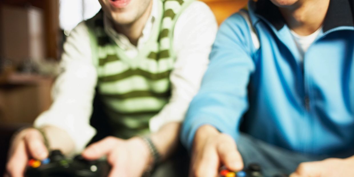 Two young men happily playing video games together indoors.