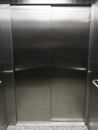 Closed stainless steel elevator doors in a modern building.