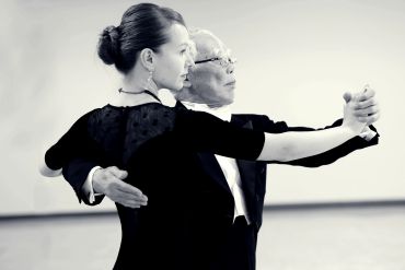 Couple dancing closely in a ballroom setting.