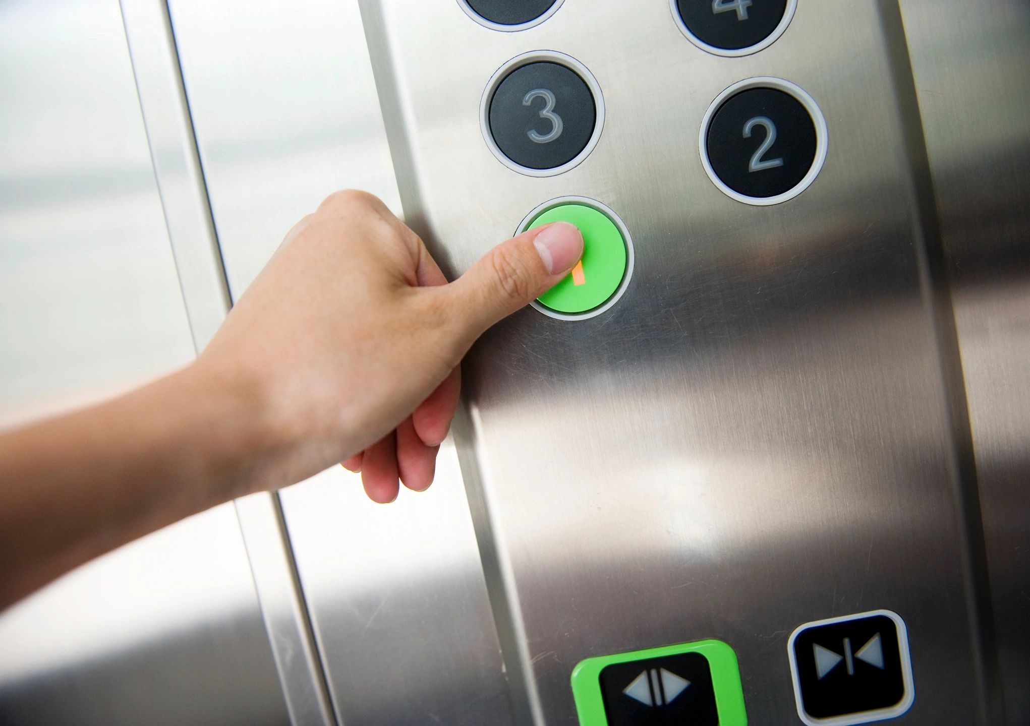 A finger pressing an elevator button