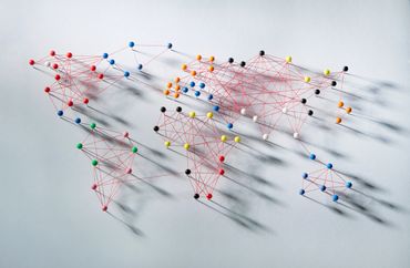 World map made with colored pins and red string on a white background.