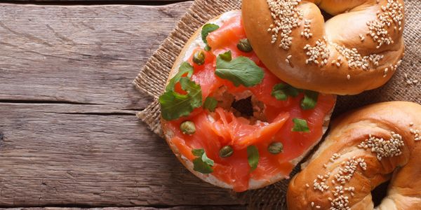 Bagel with smoked salmon and capers on rustic background.