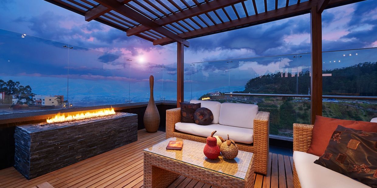 Cozy outdoor seating area with fire pit and scenic mountain view at dusk.