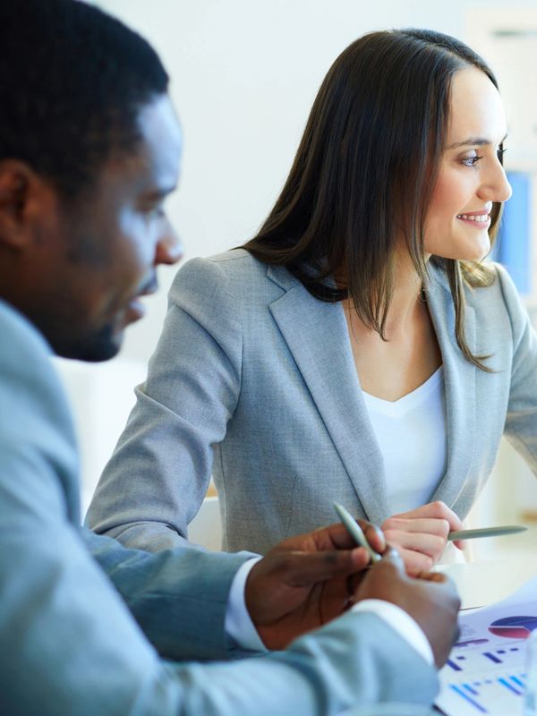 Three colleagues discussing documents in a meeting.