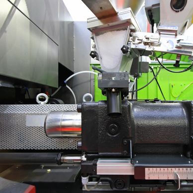 Close-up of an industrial machine part with metal components and measurement scale.