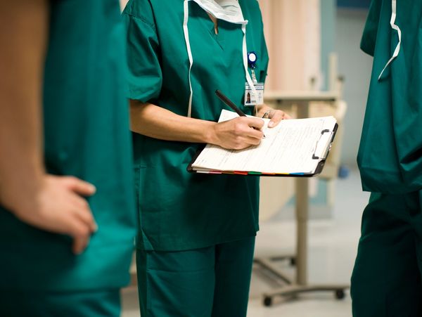 medical staff making notes on a clipboard