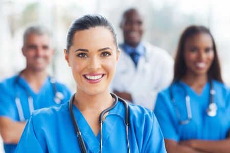 Smiling diverse medical team in blue scrubs.