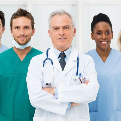 Group of diverse medical professionals in scrubs and lab coat.