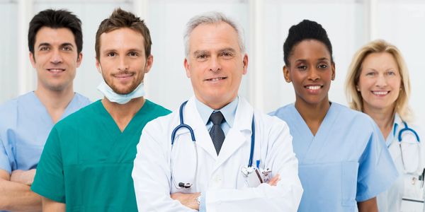 Group of five diverse healthcare professionals smiling confidently.