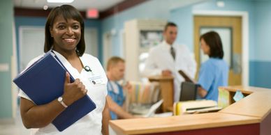 Several doctors and nurses are standing and talking around a desk in a clinic or hospital.