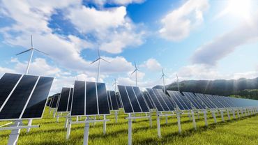 Solar panels and wind turbines harnessing renewable energy under a bright sky.