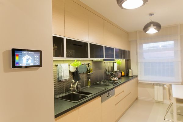 Modern kitchen with smart home control panel and sleek design.