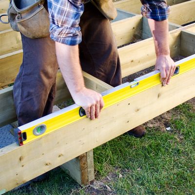 Contractor building a new deck using a level 