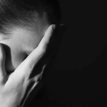 A woman with her hand over her face