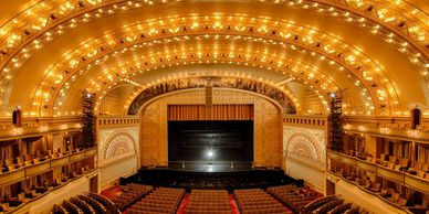 Interior of a grand, illuminated theater.