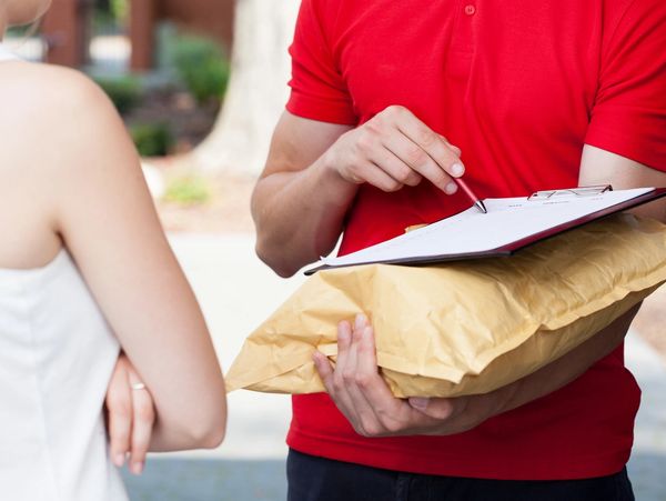 Delivery person getting signature for a package from a customer.