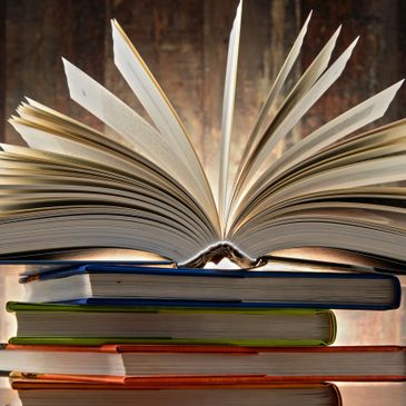 An open book on top of a stack of books