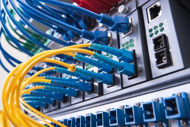 Close-up of network cables plugged into a server rack.