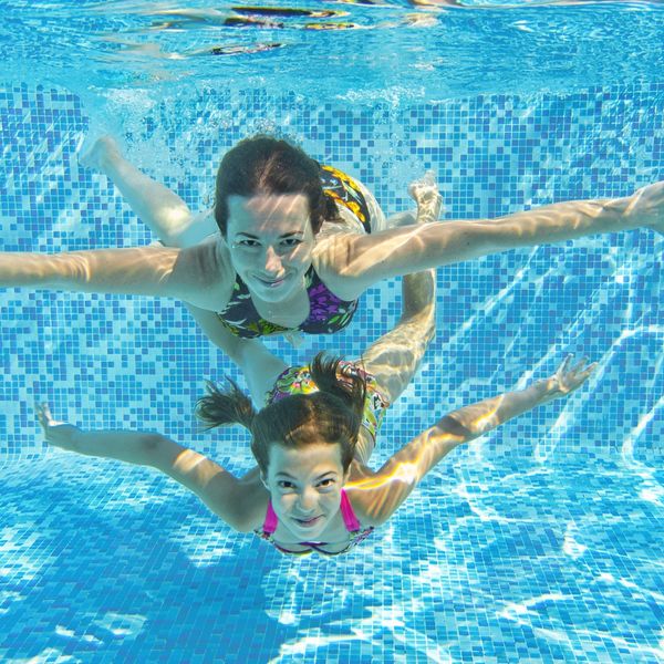 Mother and Daughter Underwater in tile pool.