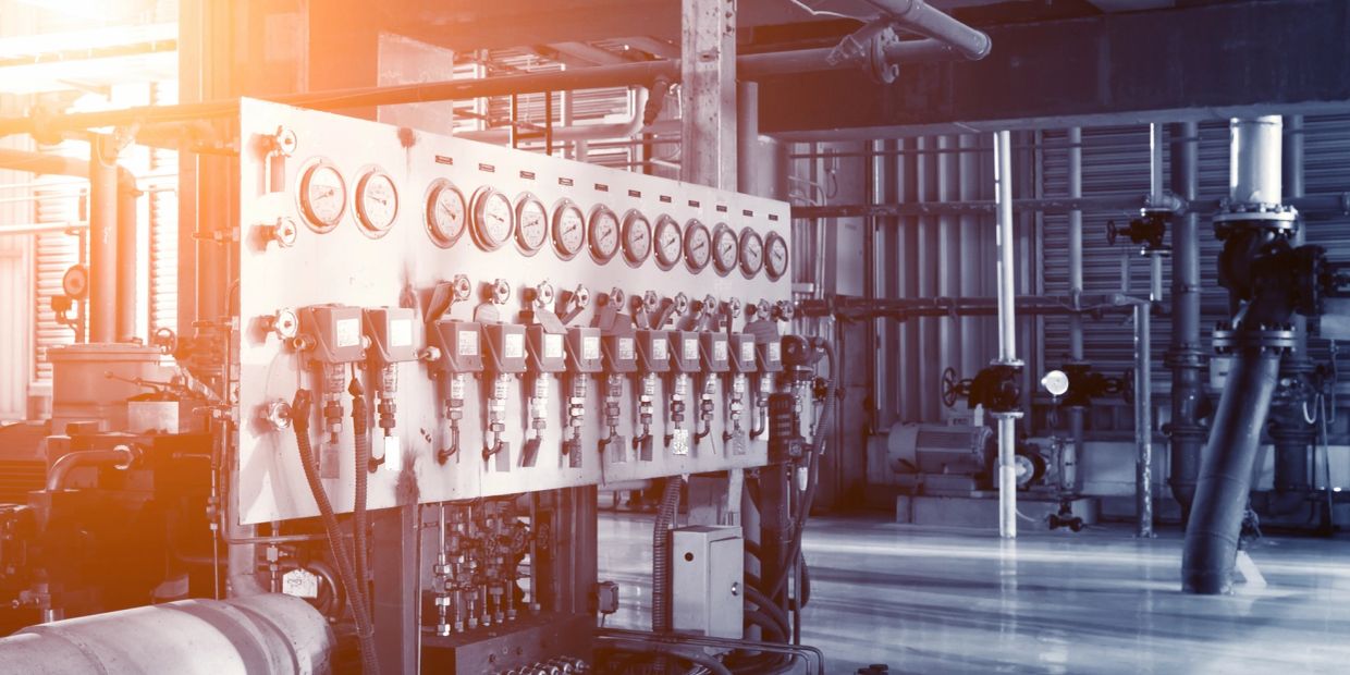 Industrial control panel with gauges and pipes.