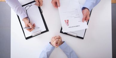 Two interviewers reviewing a candidate's resume during a job interview.