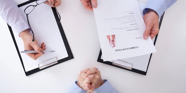 A group of people sitting at a table with papers.