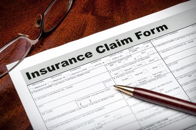 an insurance form with a pen and someone's eyeglasses