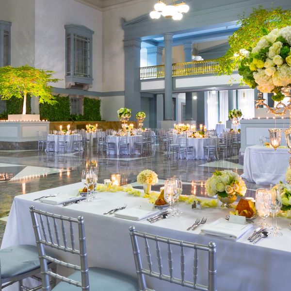 Elegant wedding reception setup with white tablecloths and floral centerpieces.