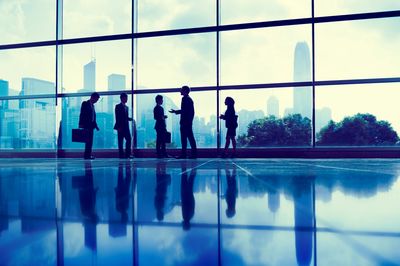 People standing in front of a window on a transparent floor talking