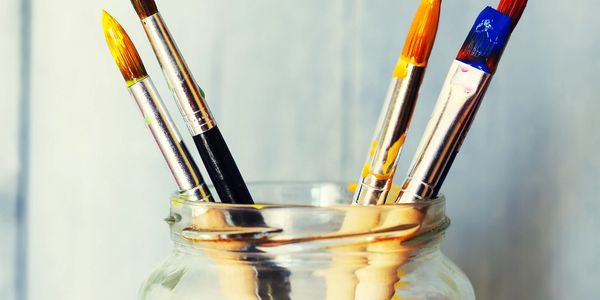 Paint brushes symbolizing artist leading to page where Cara Valentino's artwork is on display.