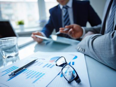 Glass of water and eye glasses on top of a meeting table