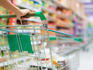 A woman pushing a green shopping cart in the store