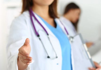 Doctor extending hand for a handshake, symbolizing care and trust.