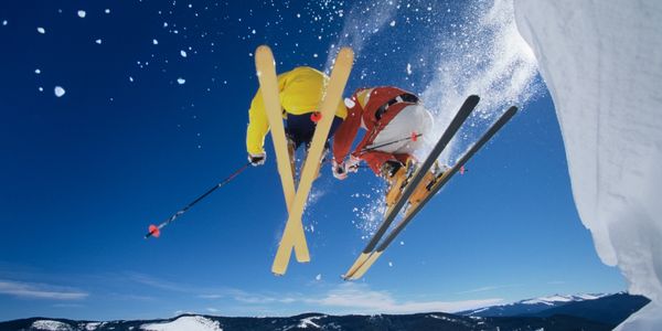 Two persons playing sky boards in the snow 