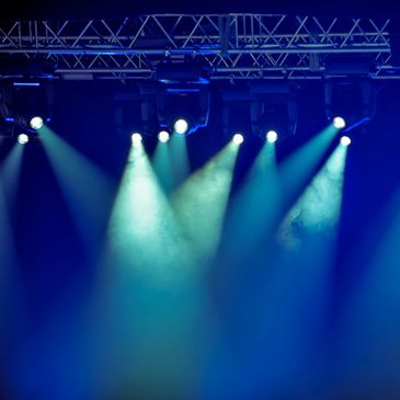 Blue stage lights shining through smoke in a dark venue.