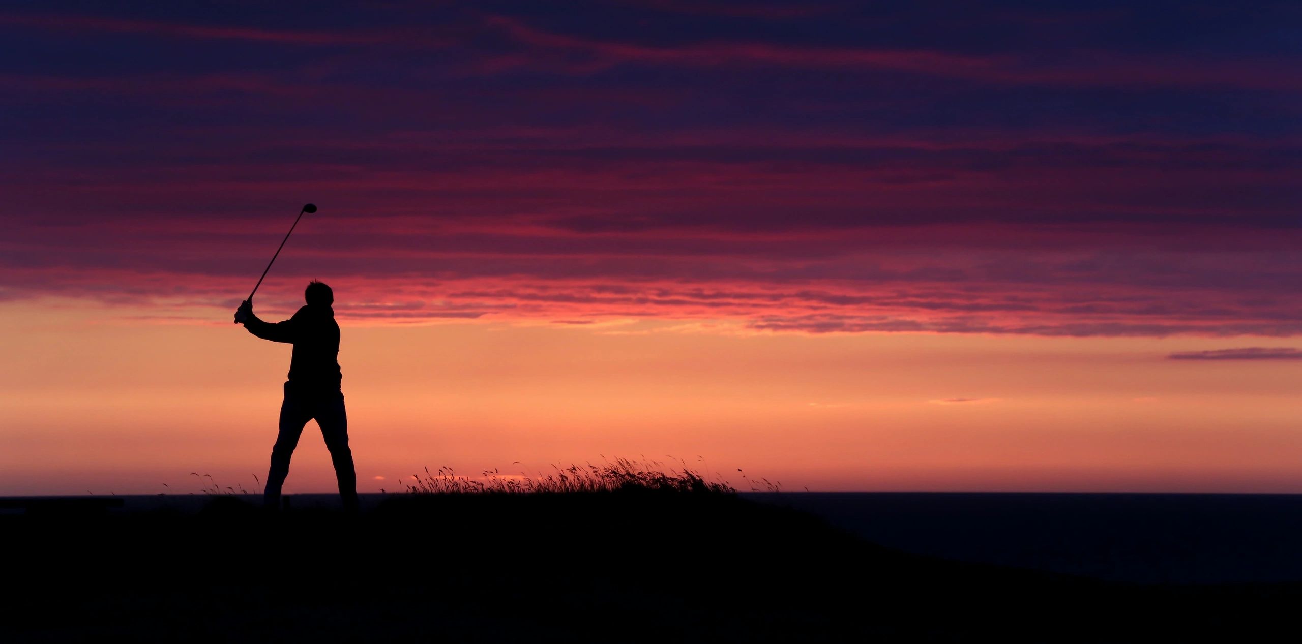 a man with a golf stick at the time of sunset 