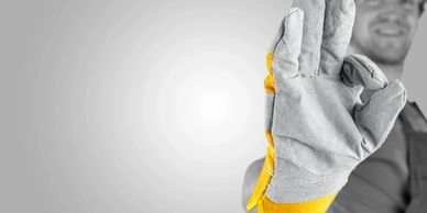Worker wearing protective gloves making an OK gesture.