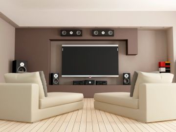 Modern living room with beige sofas and a home theater system.