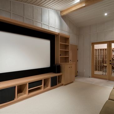 Home theater Projector with screen built into wall unit with full surround system installed.