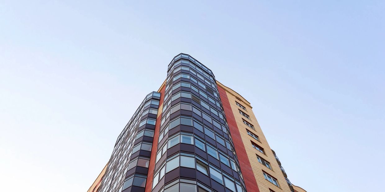 Modern high-rise building from a low angle with clear sky.