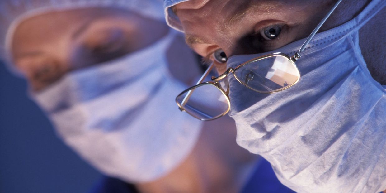 Two surgeons intensely focused during an operation.