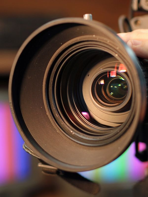 Close-up of a camera lens showing intricate glass elements and reflections.