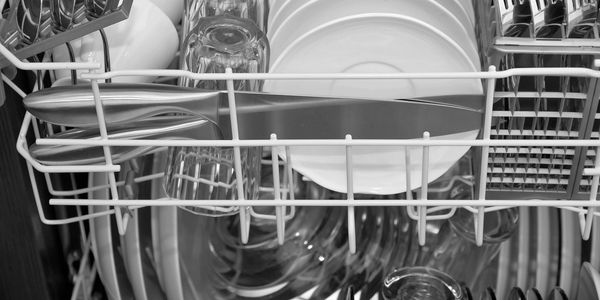 Dishwasher loaded with clean plates and glasses.